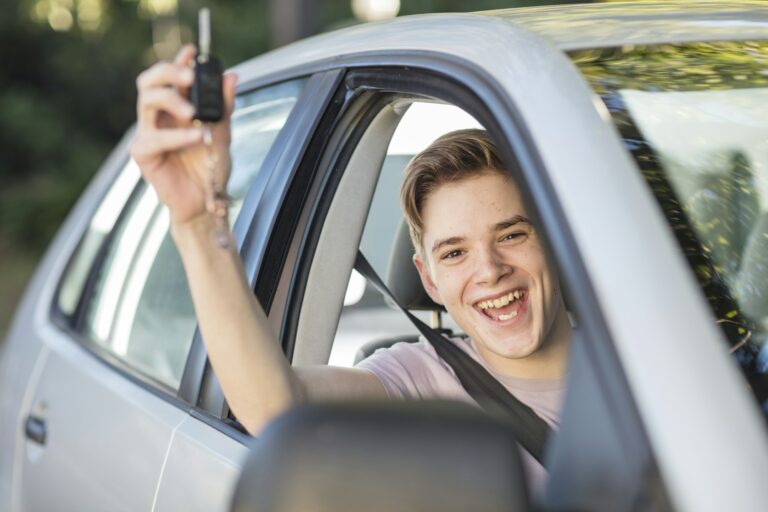 Newly qualified driver holding car keys after passing their driving test